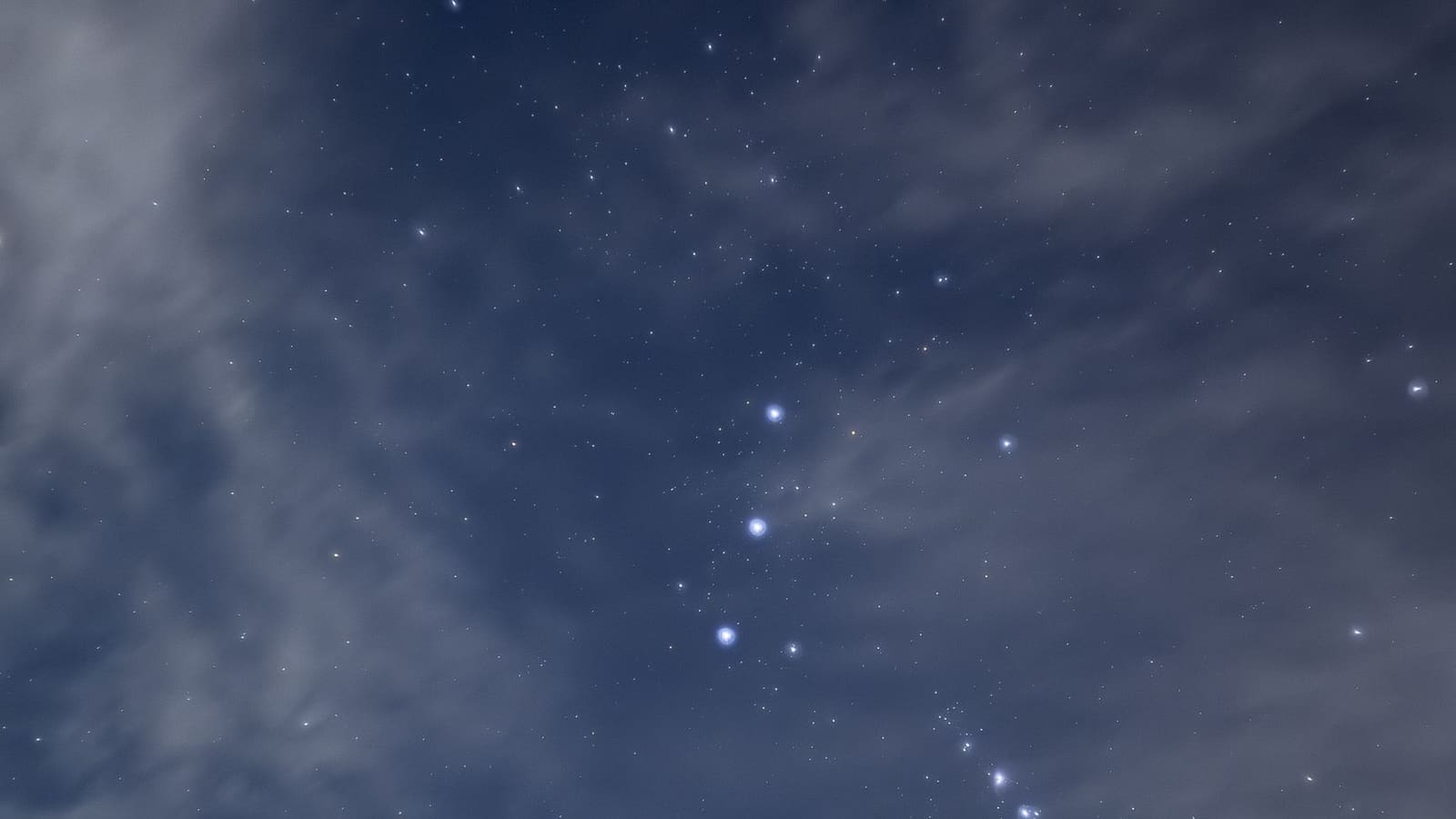 La costellazione di Orione tra le stelle e le nuvole del cielo notturno